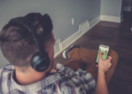 Mann som sitter og lytter til en lydbok