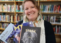 Bibliotekar Heidi Vestbye med magasiner i hånden.