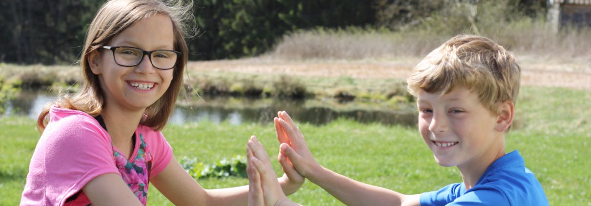 Barn med hendene mot hverandre.