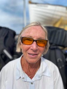 En kvinne med solbriller på en båt.