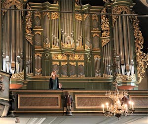 En person sitter på en orgelkrakk i Oslo domkirke og spiller orgel.