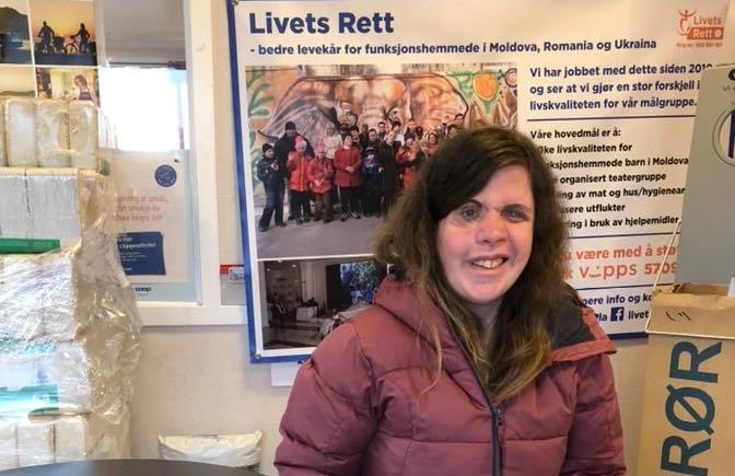 Tanita Thomassen sitter foran en plakat der det står Livets Rett
