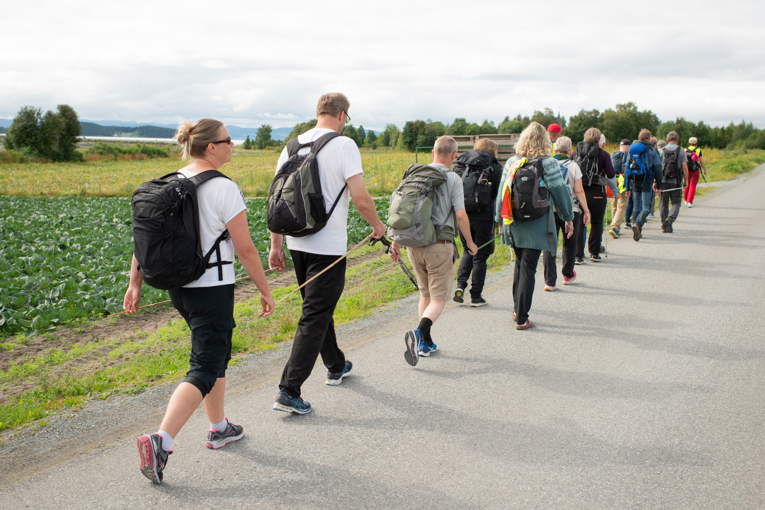 En mann overrekker et bilde til to kvinner