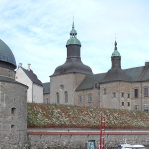 Vadstena Slott består av mange bygninger med tårn. Slottet ligger helt ved vannkanten