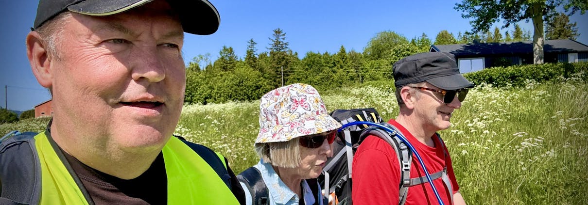 Tre personer går sammen ute i naturen